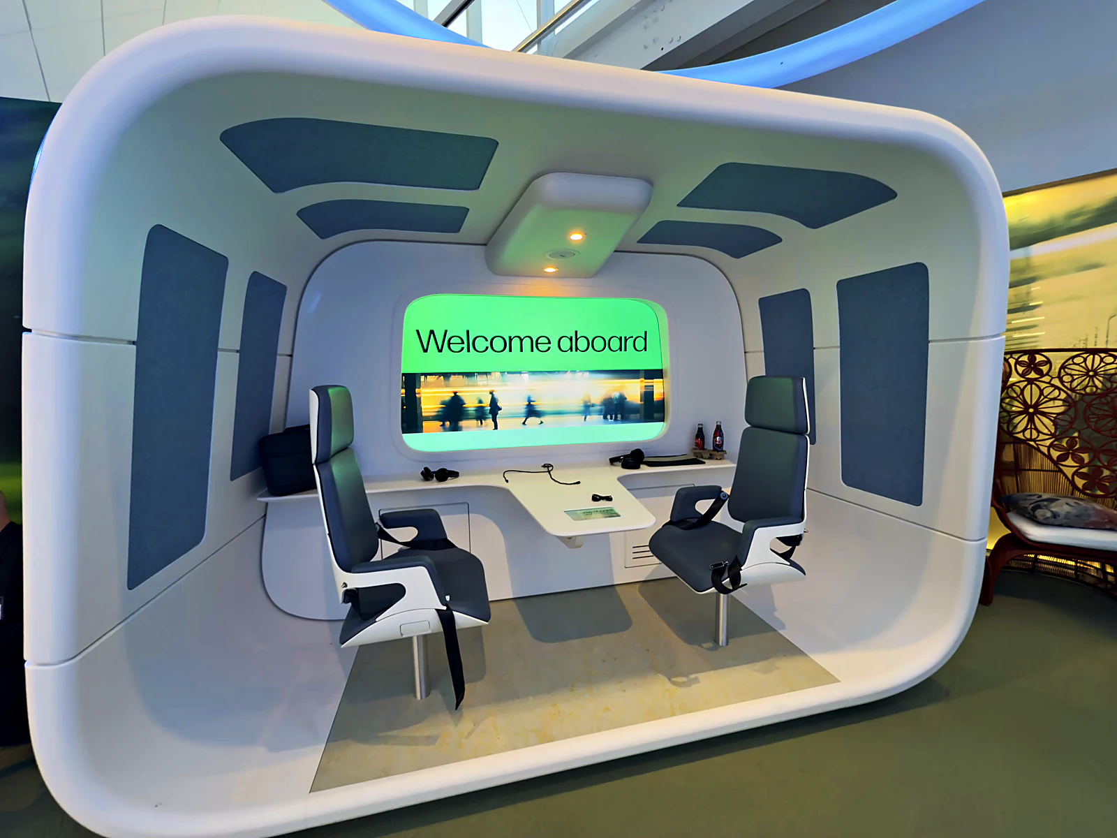 Immersive welcome-aboard experience pod with harness seats and a panoramic screen