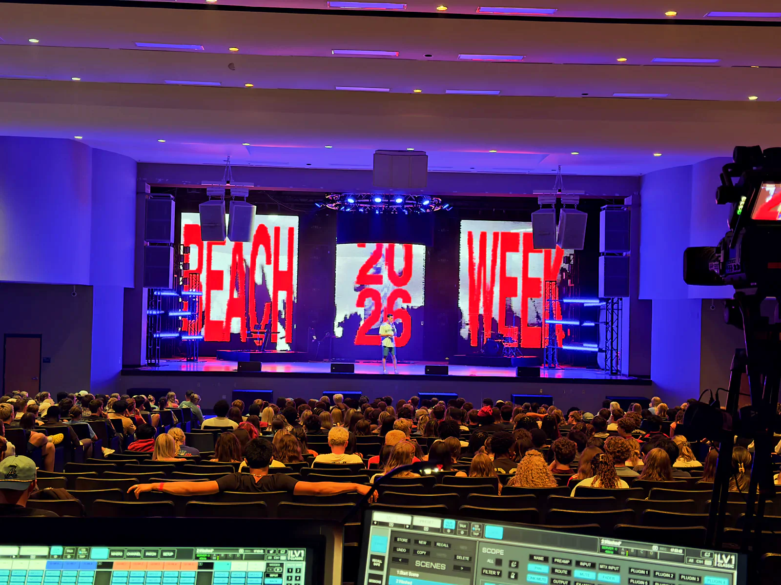 Line-array PA flown above a packed live-event floor at front-of-house