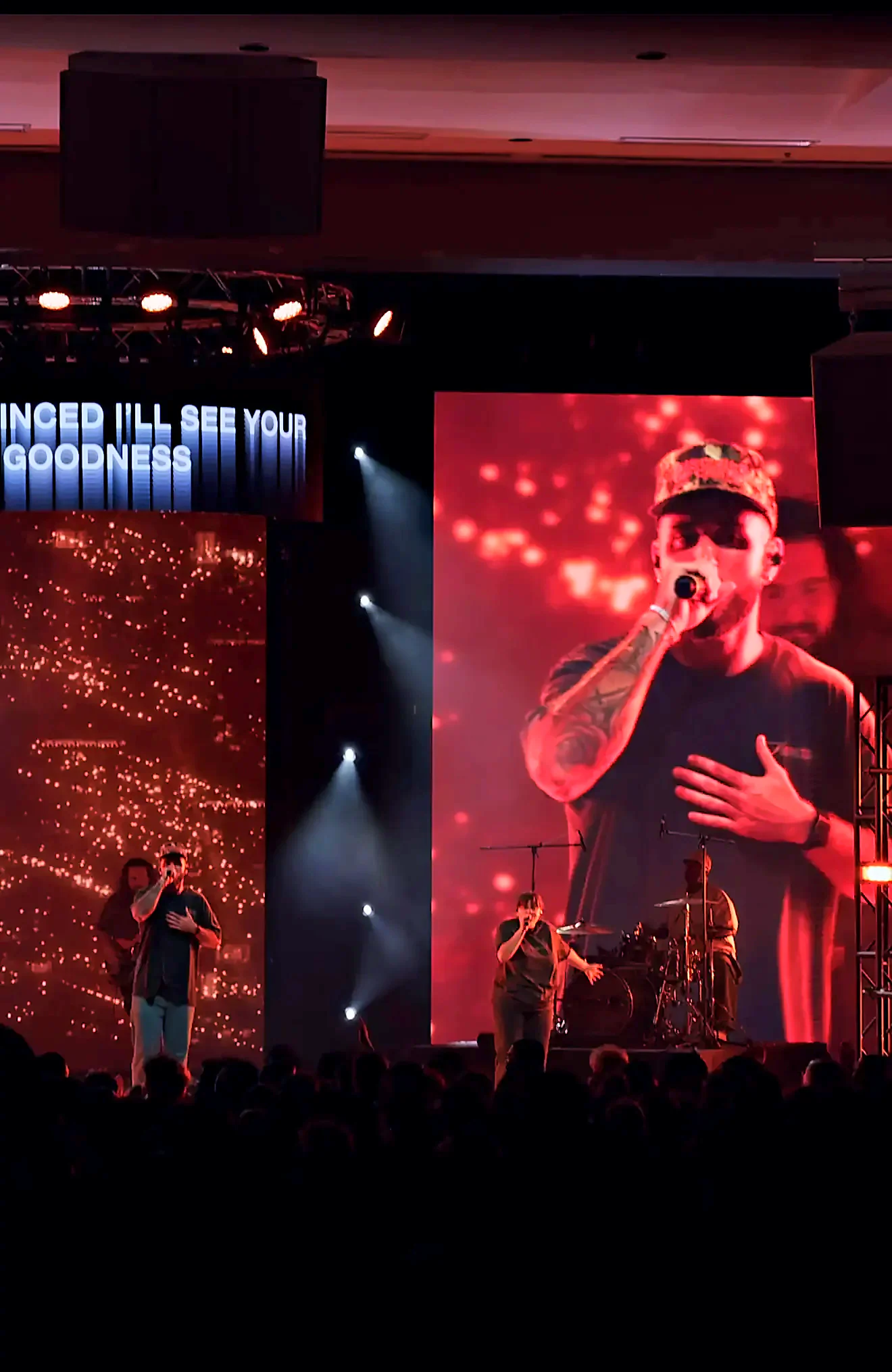 Beach Week 2026 live session: vertical IMAG screen carrying a close-up of the performer over the student crowd, with haze and beam lighting