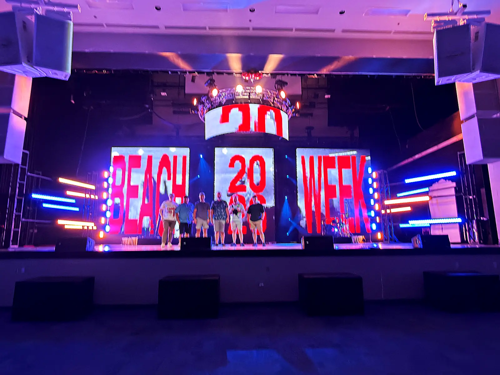 Space City Pro crew on the Beach Week stage during the build, with the LED wall and color-bar towers lit behind them