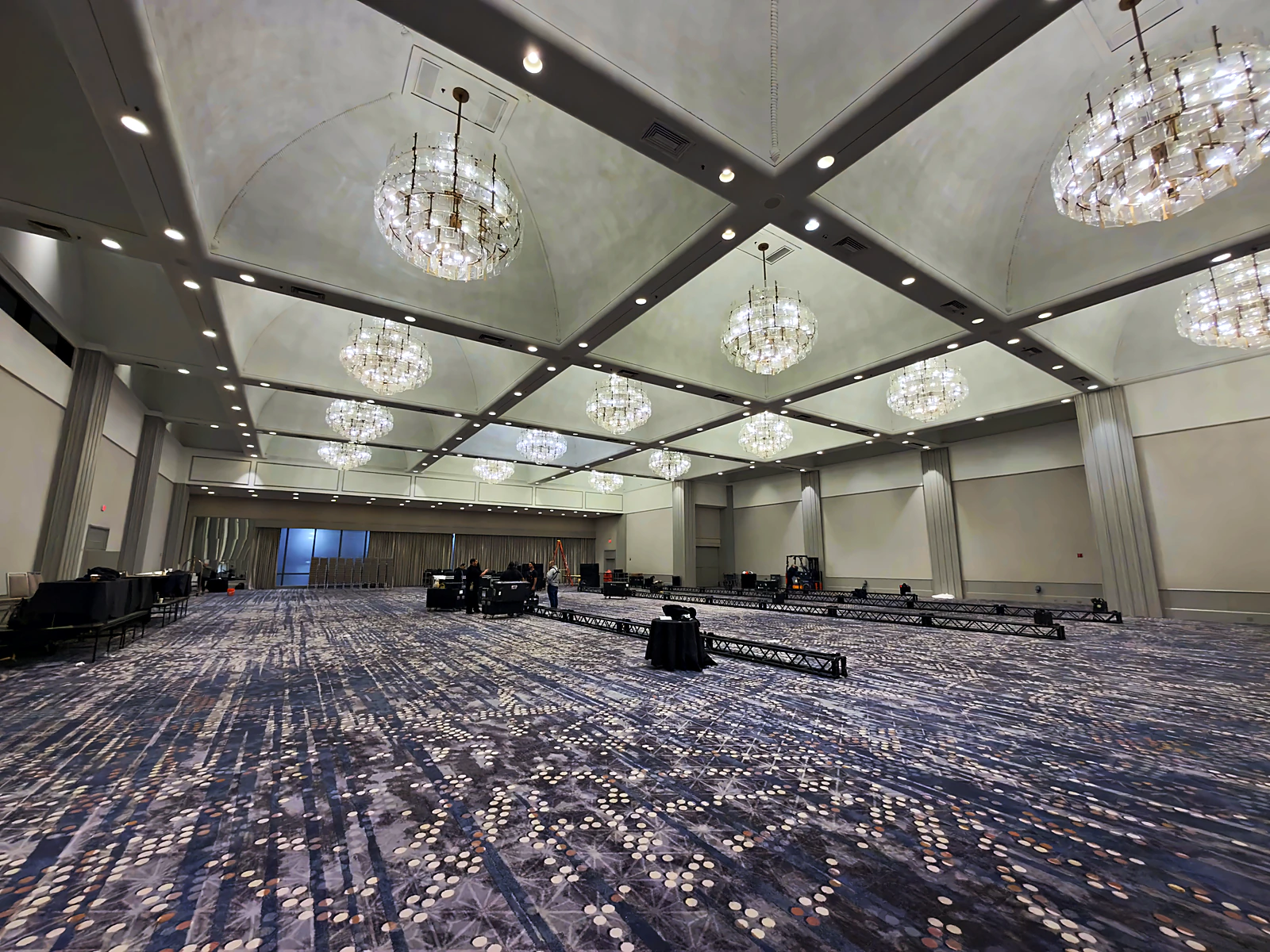 The hotel ballroom as found: chandeliers, empty carpet, and truss staged flat on the floor before the build