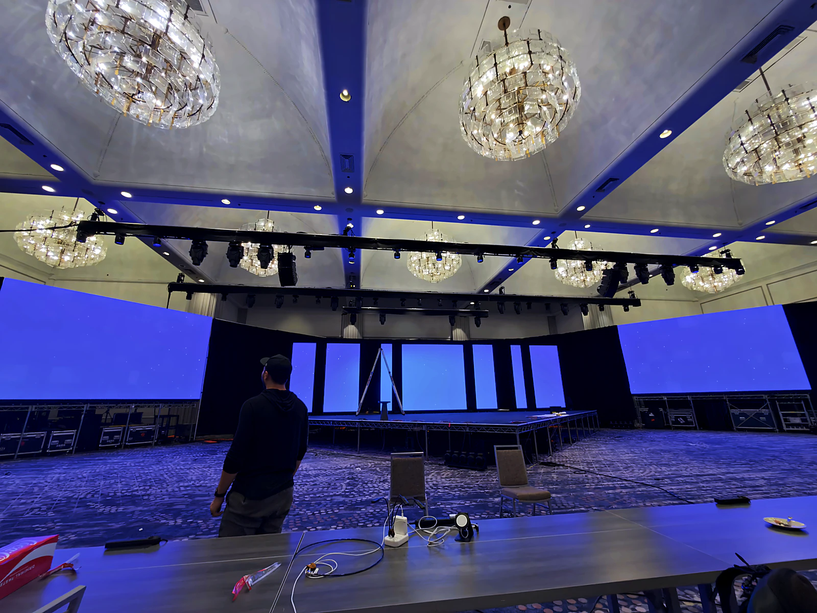 Wraparound LED surfaces lit blue across the general-session stage during programming