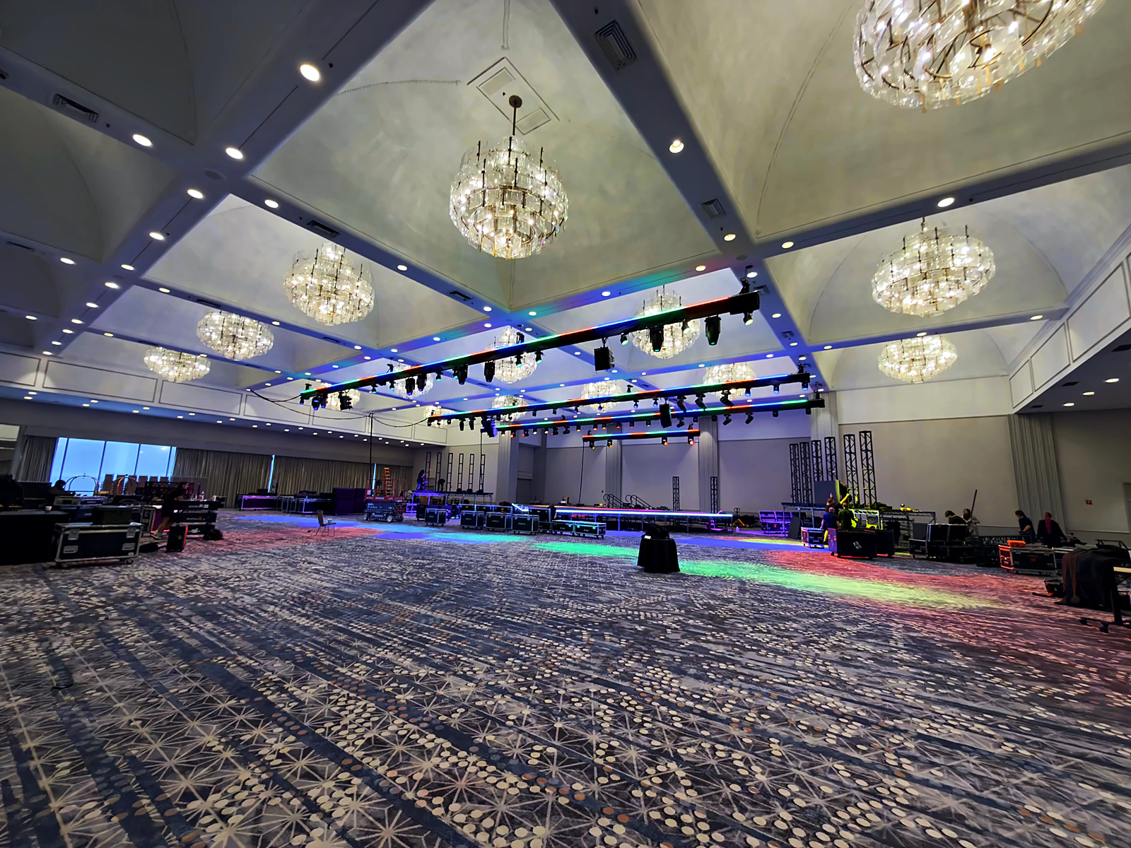 Lighting truss flown with color-bar fixtures lit during the ballroom build