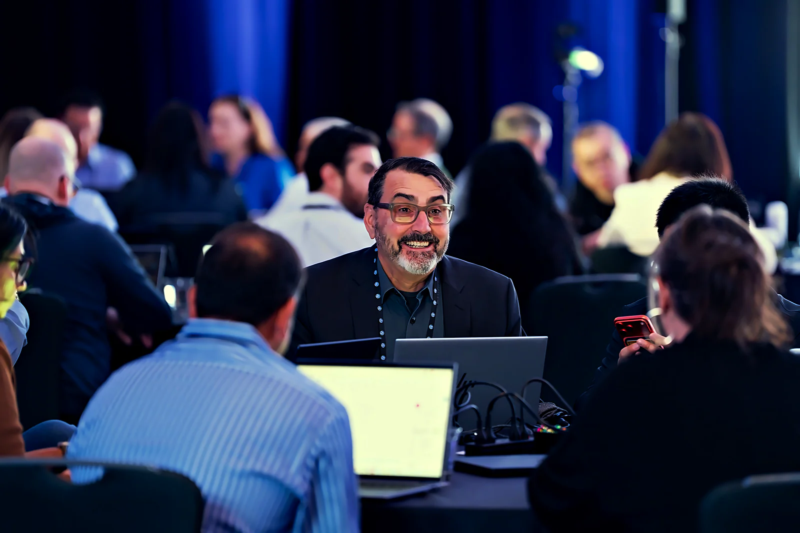 Breakout working session in progress: attendees at tables with laptops, mid-discussion