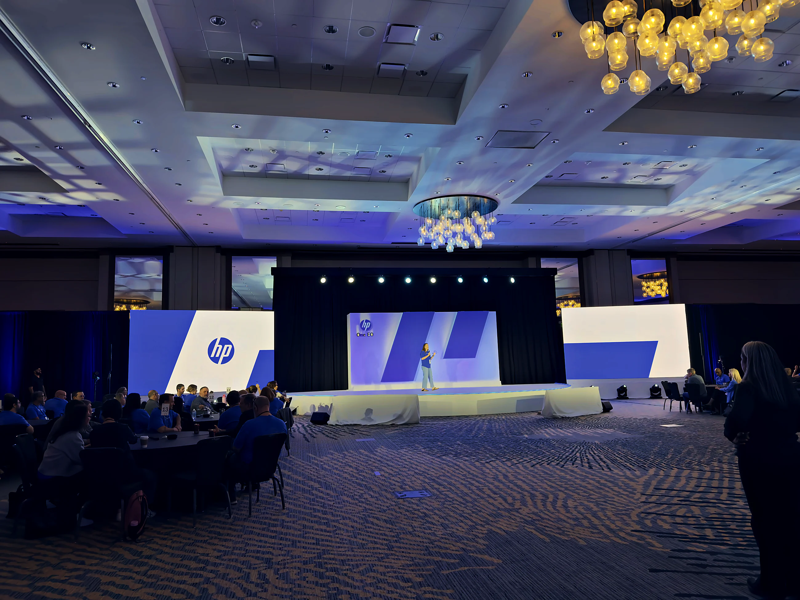 Executive summit audience facing a custom half-circle keynote stage