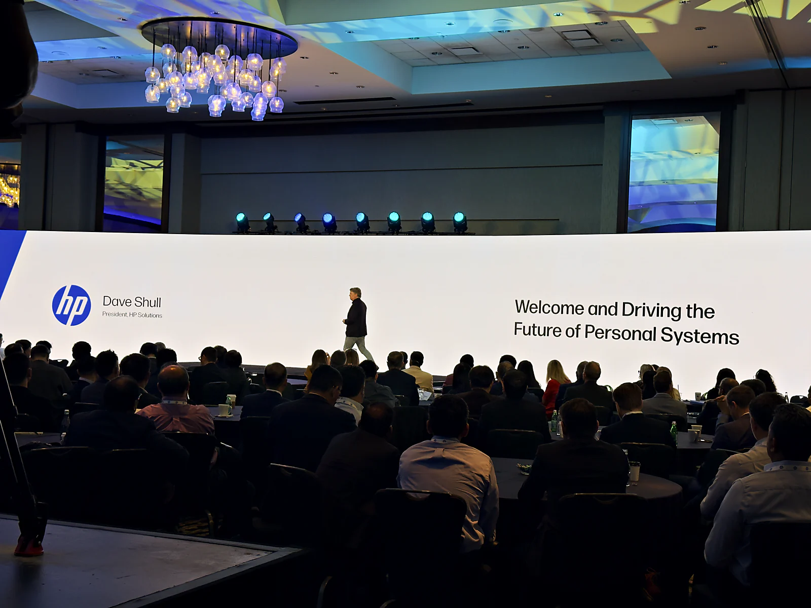 Supplier summit general session in front of a large LED wall