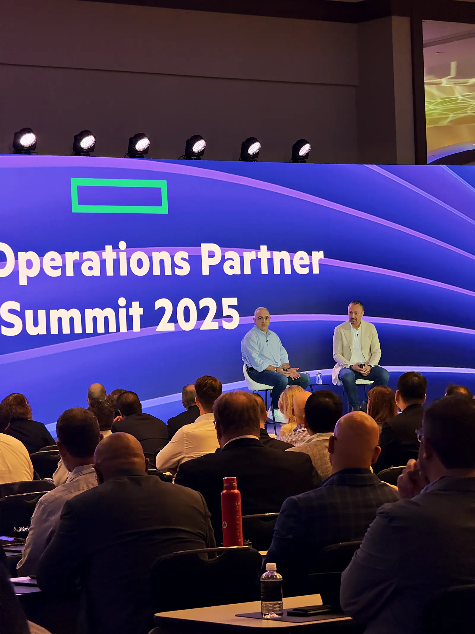 Fireside chat on stage under the HPE LED wall with the audience in frame